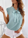 Women's summery sleeveless blouse with polka dots, ruffles and bow detail