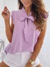 Women's summery sleeveless blouse with polka dots, ruffles and bow detail