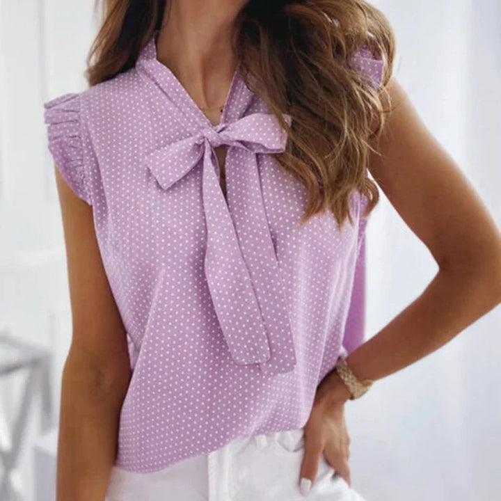 Women's summery sleeveless blouse with polka dots, ruffles and bow detail