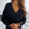 Elegant women's jumper with V-neck and gold buttons